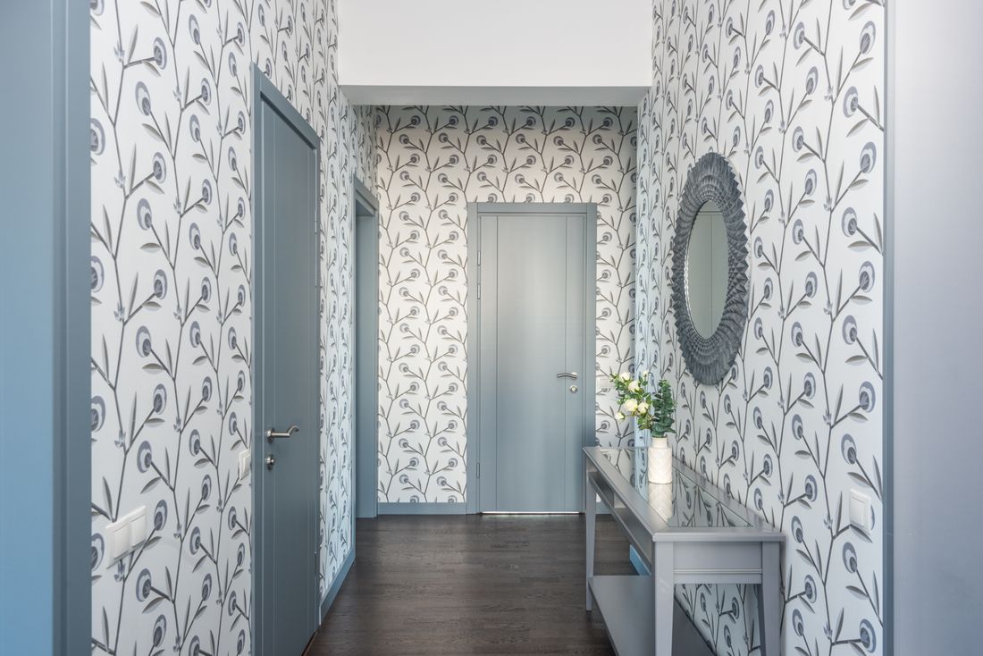 An entryway with a console table, vase and mirror.