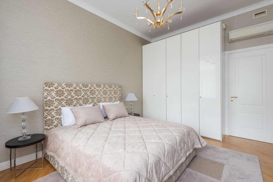 A bedroom with bedside storage and a fitted closet.