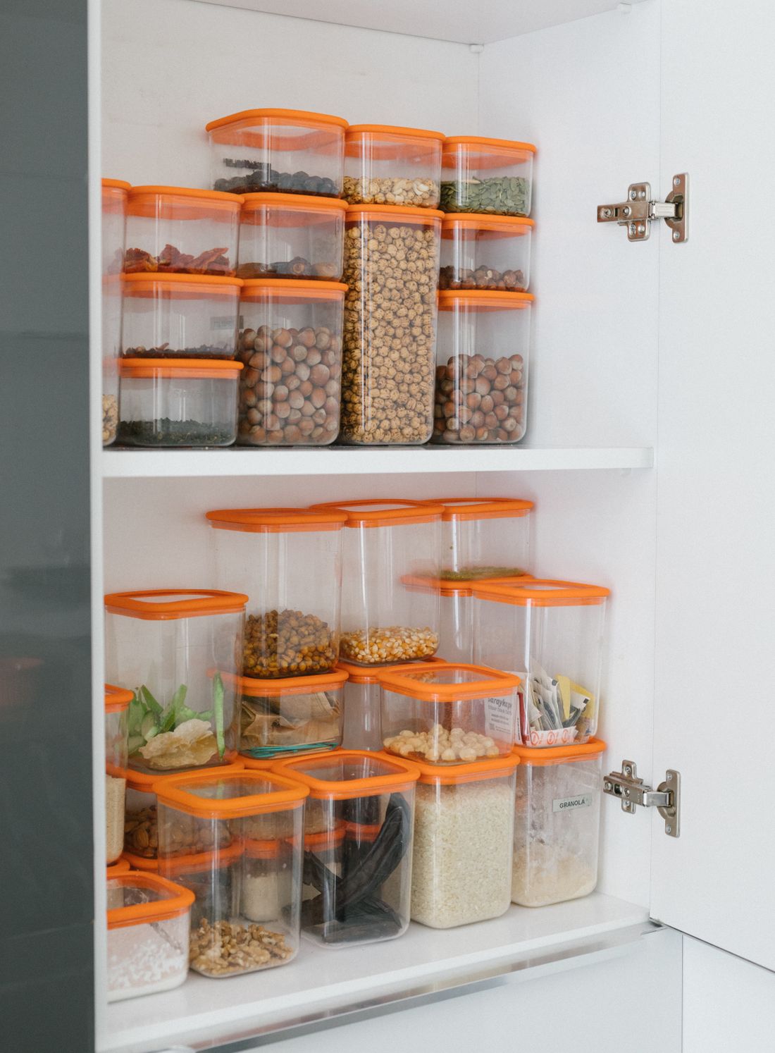 Pantry shelves with grains and seeds in clear containers.